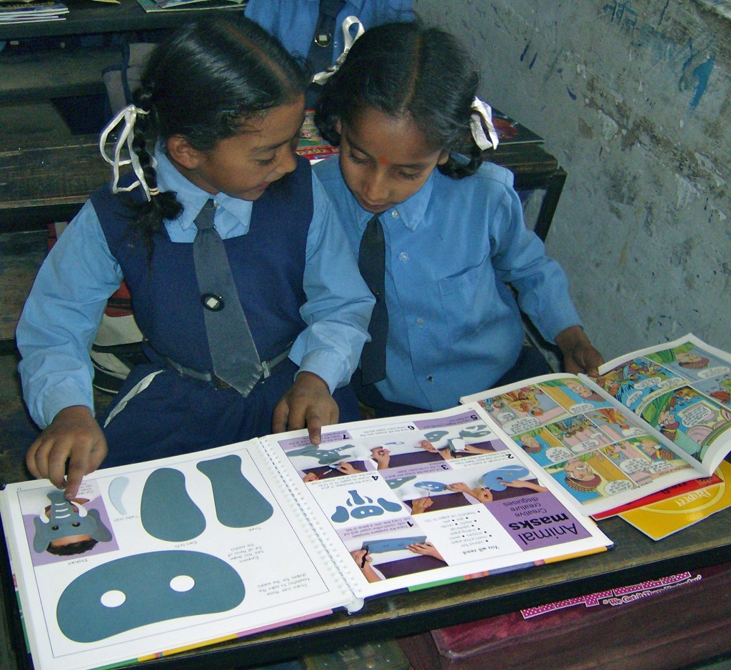 School girls giggle over their first storybooks